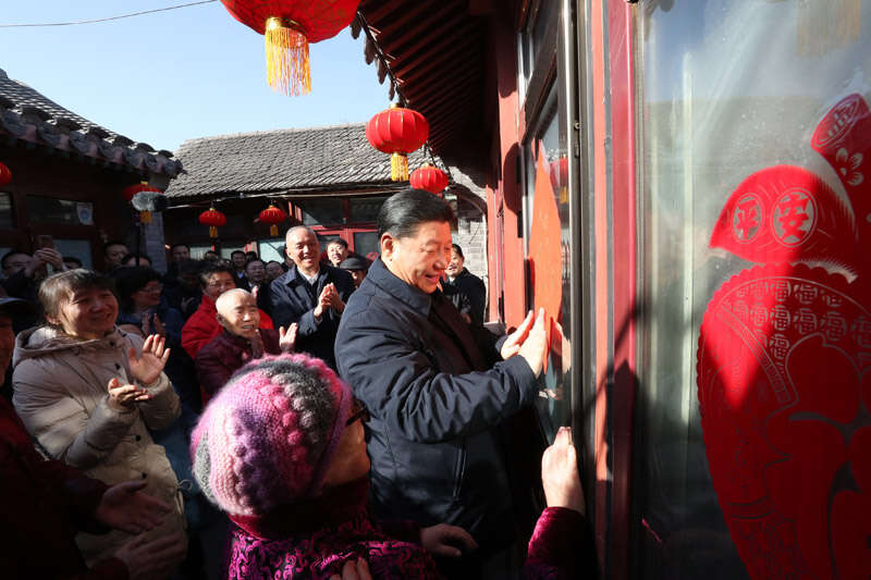 2019年2月1日上午，習近平在北京前門(mén)東區草廠(chǎng)四條胡同32號院，高興地拿起一幅“福”字，親自貼到門(mén)上，給這里的老街坊們拜年。新華社記者 鞠鵬 攝